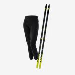 Schwarze Langlaufhose und ein Paar schwarz-gelbe Langlaufskier mit Bindungen, dargestellt auf weißem Hintergrund.