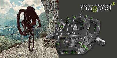 Ein Mountainbiker macht einen Wheelie auf einem felsigen Pfad mit Bergen im Hintergrund. Rechts ist ein Bild von magnetischen Sicherheitsfahrradpedalen von Magped vor einem dunklen Hintergrund zu sehen, mit dem Logo und dem Text „Magnetische Sicherheitsfahrradpedale von Magped“.