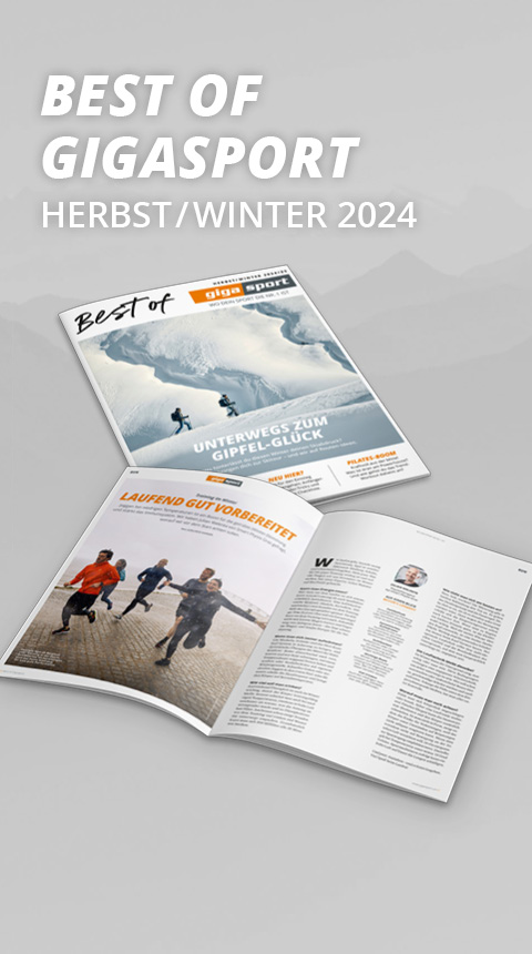 Zwei aufgeschlagene Magazine mit dem Titel „Best of Gigasport Herbst/Winter 2024“ werden gezeigt. Eines zeigt Wandern im Schnee, das andere Läufer auf einer Laufstrecke. Der Hintergrund ist ein Grauverlauf mit Bergsilhouetten.
