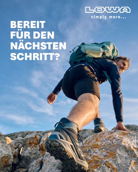 Eine Person in Wanderkleidung und mit Rucksack klettert unter blauem Himmel über felsiges Gelände. Der Text lautet: „BEREIT FÜR DEN NÄCHSTEN SCHRITT?“ und in der oberen rechten Ecke ist das LOWA-Logo zu sehen.