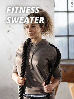 Eine Frau, die einen blauen Sport-BH und Leggings trägt, hebt beim Sport ihren Arm. Der Text "FITNESS BRAS" erscheint in fetten weißen Buchstaben oben links.