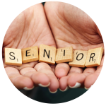 Die Hände halten Scrabble-Steine, die das Wort "SENIOR" ergeben.