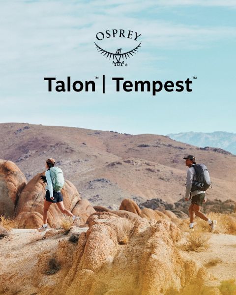 Eine Person steigt mit einem grünen Rucksack, einer schwarzen Mütze und dunkler Kleidung ein felsiges Gelände hinab. Sonnenlicht beleuchtet die Landschaft. Im Vordergrund ist das Osprey-Logo zu sehen.