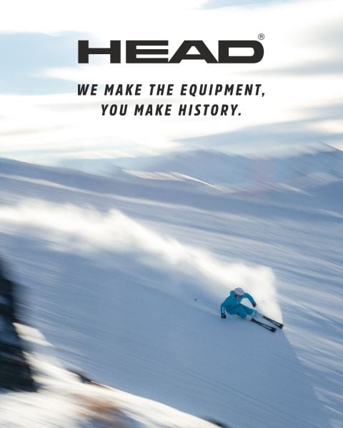 Ein Skifahrer in Blau fährt auf einer verschneiten Piste mit der Aufschrift: "HEAD. Wir machen die Ausrüstung, Sie machen Geschichte.