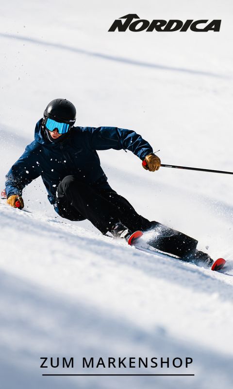 Ein Skifahrer in dunkler Kleidung und mit Helm fährt durch den Schnee. Oben ist das Nordica-Logo zu sehen, unten steht "ZUM MARKENSHOP".