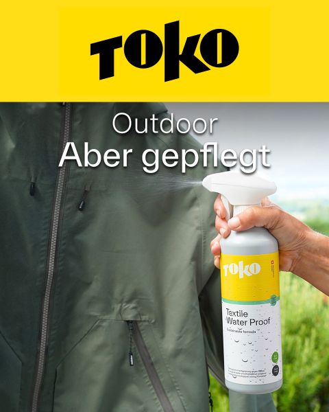 Eine Hand sprüht Toko Textile Water Proof auf eine grüne Outdoor-Jacke. Der Text lautet: "Outdoor Aber gepflegt." Das Toko-Logo befindet sich oben.