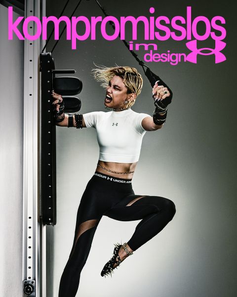 Eine Frau in Trainingskleidung tritt heftig gegen einen Boxsack; "kompromisslos" und der Schriftzug Under Armour erscheinen in fetter rosa Schrift über ihr.