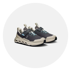 Ein Paar schwarze und beige Sportschuhe mit blauen Akzenten, Klettverschlüssen und dicken Sohlen, dargestellt vor einem weißen Hintergrund.