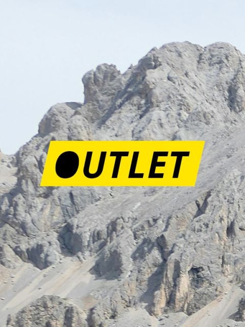 Das Wort „OUTLET“ in schwarzer Schrift auf einem gelben rechteckigen Hintergrund, überlagert von einem felsigen Berggipfel.